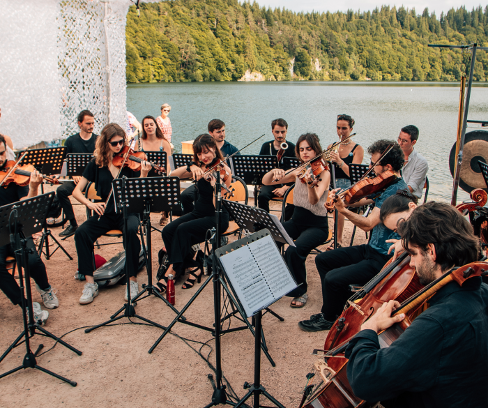 Musiciens du festival jouant au bord d'un lac